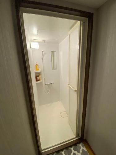 a bathroom with a shower with a glass door at Arashi no Yakata in Hamamatsu