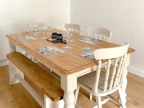 a dining room table with wine glasses on it at Snowdrop Cottage in Fishguard