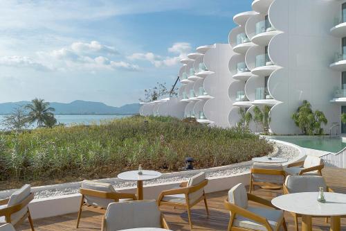 a restaurant with tables and chairs on the side of a building at Veranda Resort Phuket, Autograph Collection in Panwa Beach