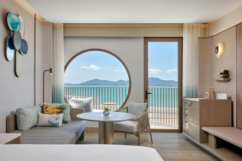 a living room with a couch and a table at Veranda Resort Phuket, Autograph Collection in Panwa Beach
