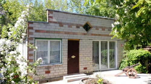 a small brick house with a brown door at Koidula Holiday Home in Narva-Jõesuu