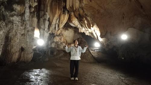 a man standing in a cave with his arms out at Higland Homestay Bac Ha in Bắc Hà