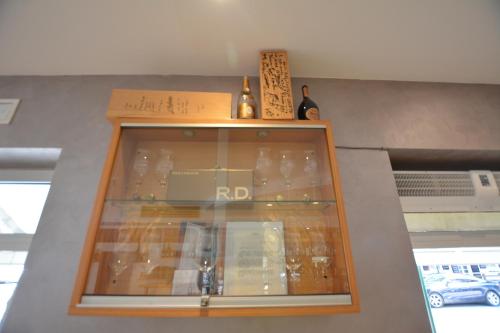 a glass cabinet with bottles on top of it at Hotel Tivoli in Lignano Sabbiadoro