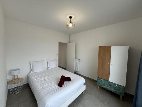 - une chambre dotée d'un lit blanc avec une paire de chaussures dans l'établissement Apartment in Le Mans near Bugatti Circuit, au Mans