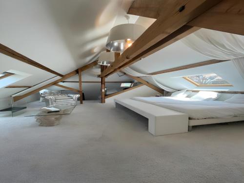 - une chambre mansardée avec un lit et un plafond voûté dans l'établissement Estate in Saint-Pavace near Le Mans Circuit, à Saint-Pavace