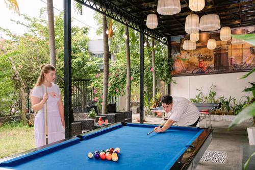 a man and a woman playing pool in a pool table at JM Hoi An Beach Hotel - Free Shuttle Car To Old Town in Hoi An