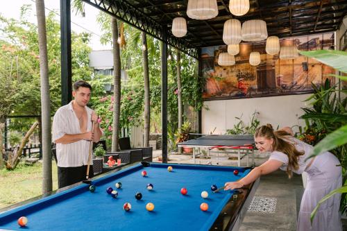 a man and a woman playing a game of pool at JM Hoi An Beach Hotel - Free Shuttle Car To Old Town in Hoi An
