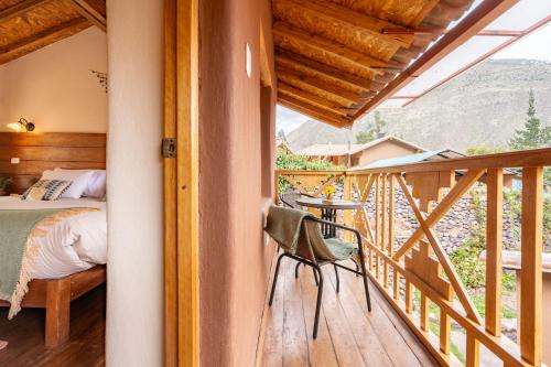 a bedroom with a bed and a table on a balcony at Unuwasi Hotel & Villa in Calca