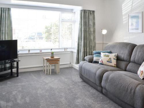 a living room with a couch and a television at Beam Cottage in Flamborough