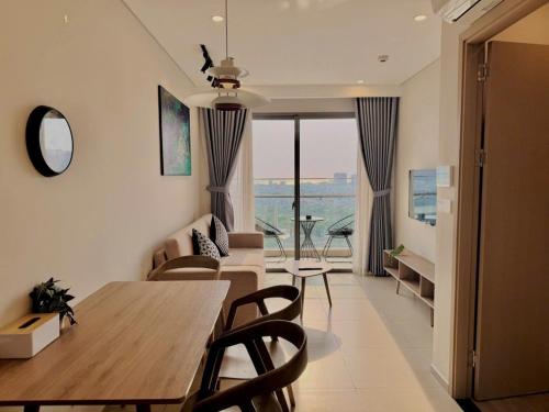 a dining room and living room with a table and chairs at The Song Tam Thang Tower in Vung Tau