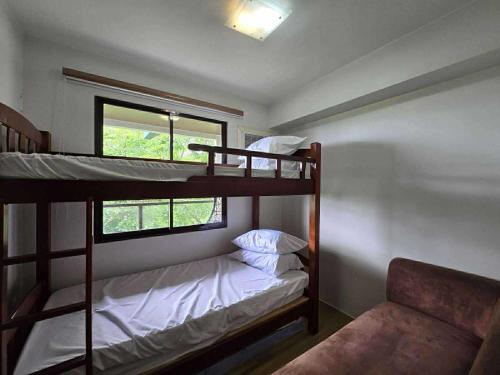 two bunk beds in a room with a window at 2BR FAMILY AFFORD STAYCATION TAGAYTAy in Tagaytay