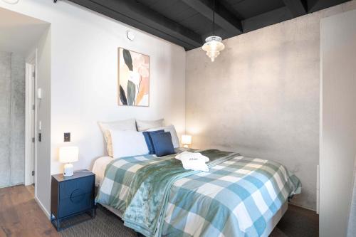 a bedroom with a bed and two lamps on a table at Cozy Studio - Private Balcony Bath and Tub in Lower Hutt