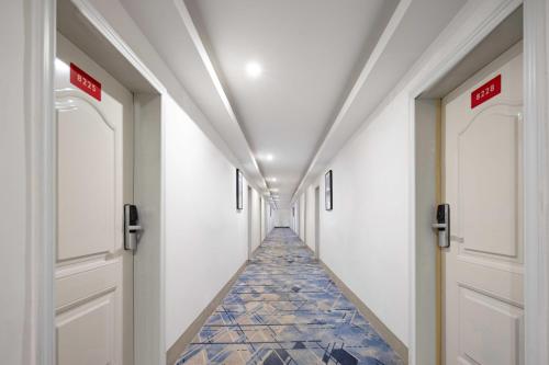 a corridor of a hospital with doors and tile floors at Hello Light Hotel Hankou Railway Station Flagship Store in Hankou Zhan