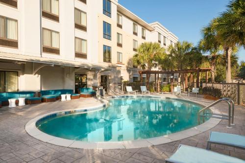 a pool at a hotel with chairs and a building at SpringHill Suites Fort Myers Airport in Fort Myers