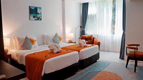 een hotelkamer met twee bedden met handdoeken erop bij Hilltop Wellness Resort in Phuket
