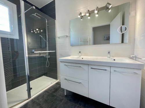 une salle de bain avec un lavabo, une douche et un miroir dans l'établissement **Maison 3 pièces avec jardin à 350m du bord de mer - Wifi, terrasse, parking** - FR-1-231-220, à Bretignolles-sur-Mer