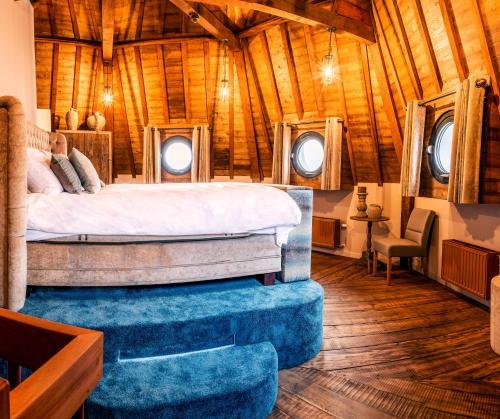 a bedroom in a log cabin with a bed and windows at De Gevangentoren Suite in Vlissingen