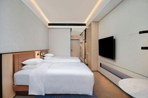 a hotel room with two beds and a flat screen tv at Four Points by Sheraton Suzhou Gusu in Suzhou