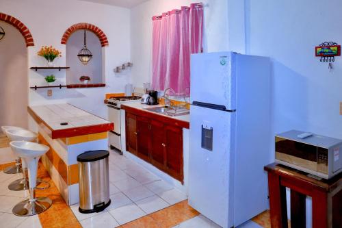 a kitchen with a white refrigerator and a microwave at Queen GrandiaHouse in Puerto Vallarta