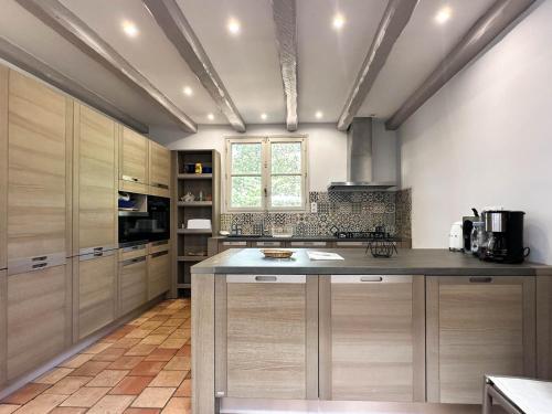 une cuisine avec des placards en bois et un grand îlot dans l'établissement Villa Charentaise avec Piscine Privée - Jusqu'à 12 Pers. - FR-1-705-89, aux Mathes