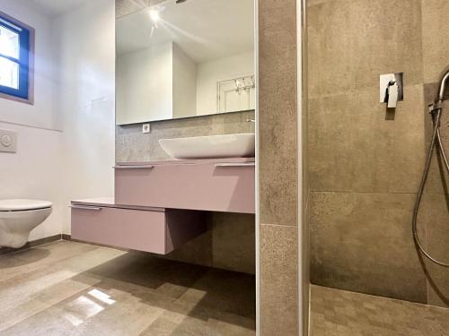 une salle de bain avec un lavabo, des toilettes et un miroir dans l'établissement Villa Charentaise avec Piscine pour 8 personnes à La Palmyre - FR-1-705-103, aux Mathes