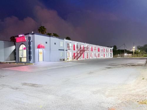 a large white building with red windows at night at La Vista Motel in Brownsville