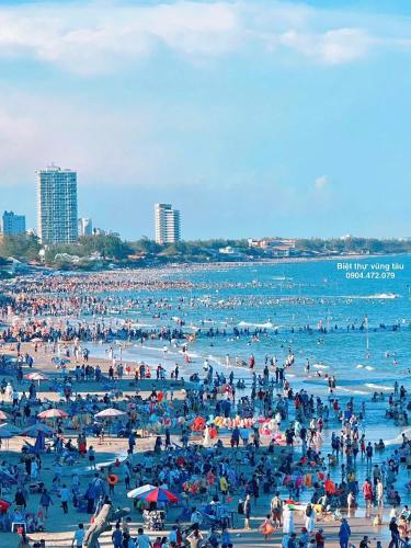 a large crowd of people on a beach at The Song Tam Thang Tower in Vung Tau