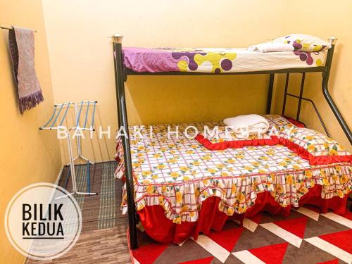 a bunk bed with a quilt on it in a room at Baihaki Homestay in Kota Bharu