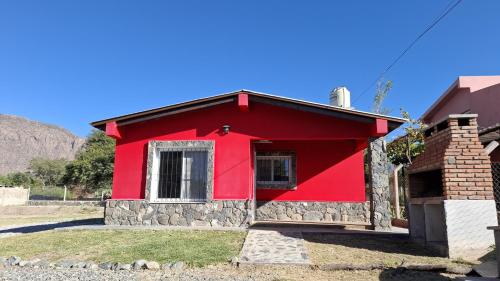a red house with a stone at Cabañas Pukara in Cafayate