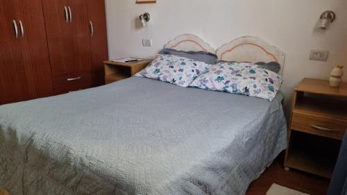 Un dormitorio con una cama con dos almohadas encima. en La Nona, en El Carmen