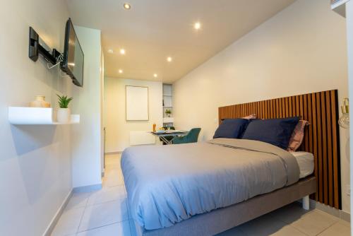 une chambre avec un lit avec une tête de lit en bois dans l'établissement Charmant Studio avec Parking Gratuit, à Vals-les-Bains