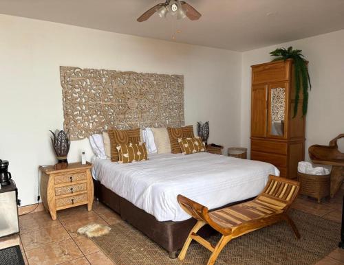 a bedroom with a large bed and a chair at Hostal Brisas del Mar in Punta Negra