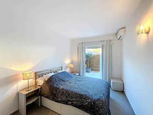 une petite chambre avec un lit et une fenêtre dans l'établissement Charmant T2 avec Terrasse, Climatisation et Parking à Saint-Cyr-sur-Mer - FR-1-770-51, à Saint-Cyr-sur-Mer