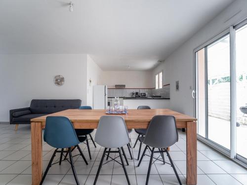 une cuisine et une salle à manger avec une table et des chaises en bois dans l'établissement Maison à Bias 6 pers – Confort et nature proche océan - FR-1-50-184, à Bias