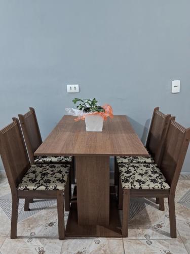 a wooden table and chairs with a plant on top at Apartamento em Santana de Parnaiba in Santana de Parnaíba