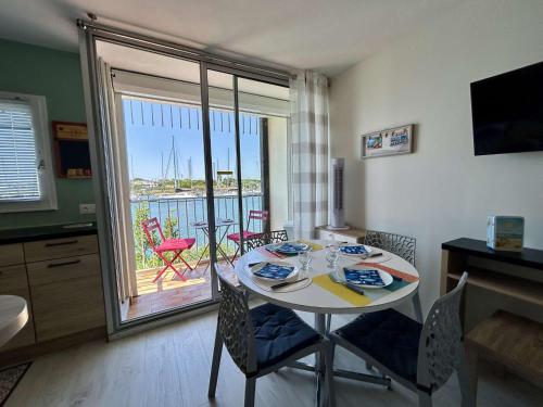 une salle à manger avec une table et des chaises et un balcon dans l'établissement Appartement T2 rénové, 4 couchages, vue port, Cap d'Agde - FR-1-249-446, au Cap d'Agde