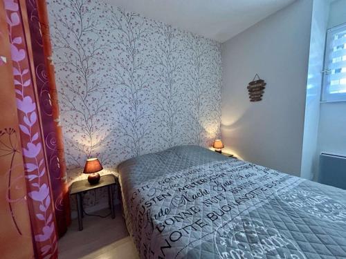 - une chambre avec un lit et deux lampes sur les tables dans l'établissement Appartement T2 rénové, 4 couchages, vue port, Cap d'Agde - FR-1-249-446, au Cap d'Agde