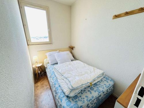 une petite chambre avec un lit et une fenêtre dans l'établissement Studio cabine avec parking au Cap d'Agde, vue port - FR-1-249-445, au Cap d'Agde