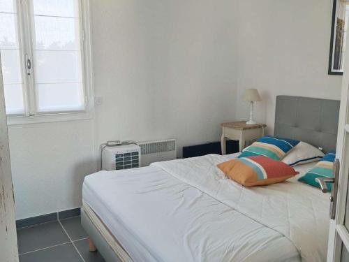 une chambre avec un lit blanc avec des oreillers et une fenêtre dans l'établissement Appartement rénové 2 chambres avec parking au Barcarès - FR-1-195-121, au Barcarès