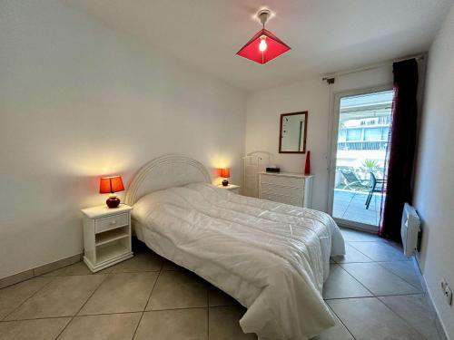 une chambre avec un lit et deux tables de nuit avec lampes dans l'établissement Appartement 2 pièces à 5 min de la mer à Golfe-Juan - FR-1-252-200, à Vallauris