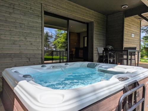une baignoire jacuzzi dans l'arrière-cour d'une maison dans l'établissement Lodge élégant avec spa privatif et espace bien-être - FR-1-582-530, au Chambon-sur-Lignon