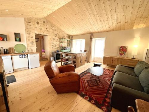 un salon avec un canapé et des chaises et une cuisine dans l'établissement Maison rénovée au cœur de Brem, 4 couchages, jardin, WIFI - FR-1-231-340, à Brem-sur-Mer