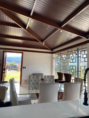 a room with white chairs and a table and windows at Hermosa casa con dos dormitorios 