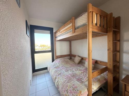 une chambre avec un lit superposé et une fenêtre dans l'établissement Spacieux T3 47m², 5 Pers, Vue Mer, Ascenseur, Animaux Admis - FR-1-799-59, au Barcarès
