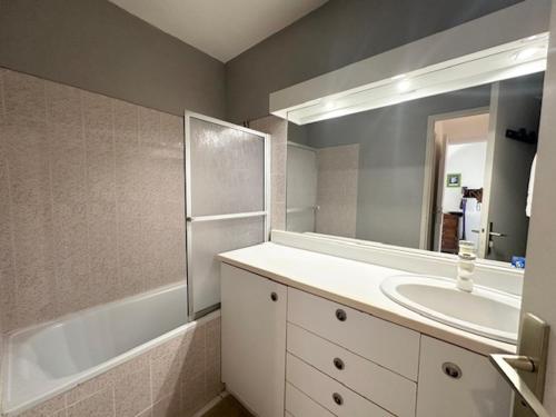 une salle de bain avec un lavabo, une baignoire et un miroir dans l'établissement Spacieux T3 47m², 5 Pers, Vue Mer, Ascenseur, Animaux Admis - FR-1-799-59, au Barcarès