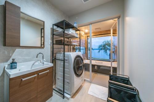 a bathroom with a washing machine and a sink at Wat resort シーフロント奥能登 in Anamizu
