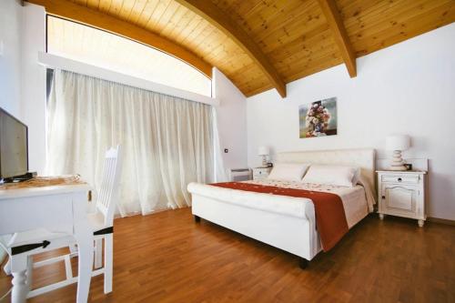 a bedroom with a white bed and a wooden ceiling at Semi-detached house with private pool in Lardos