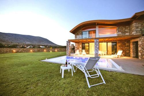 a house with a pool and two chairs in the yard at Semi-detached house with private pool in Lardos