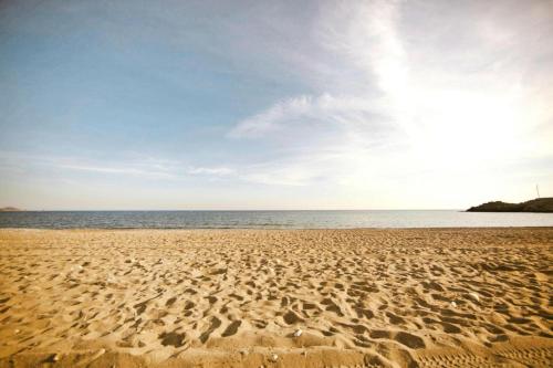 a sandy beach with the ocean in the background at Semi-detached house with private pool in Lardos