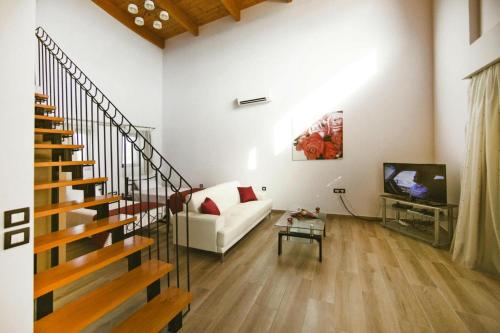 a living room with a white couch and a tv at Semi-detached house with private pool in Lardos